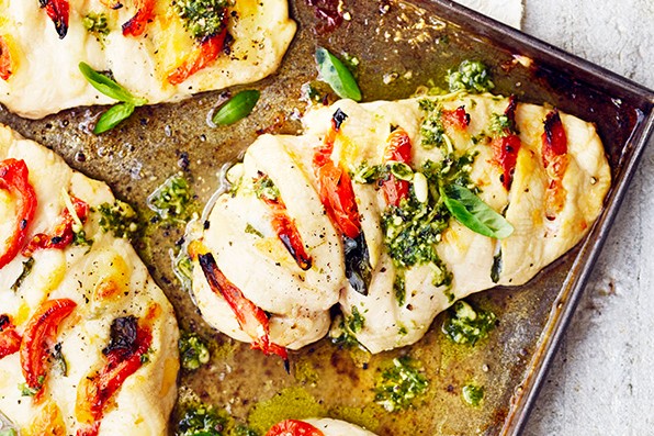 Tray of stuffed hasselback chicken breasts with pesto
