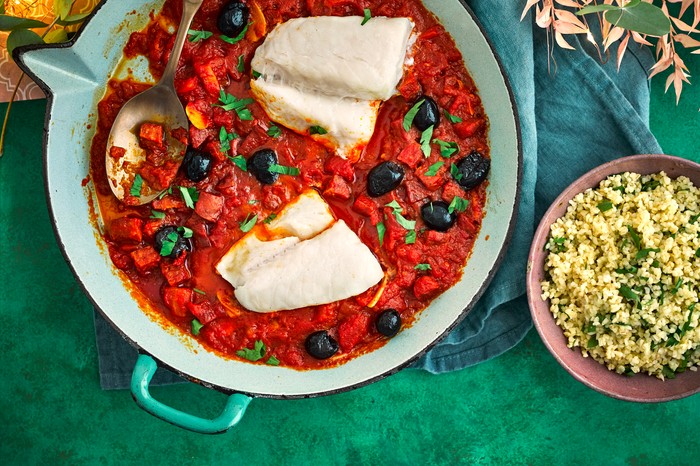 Two cod fillets in a tomato and chorizo sauce, served with a bowl of bulghar wheat