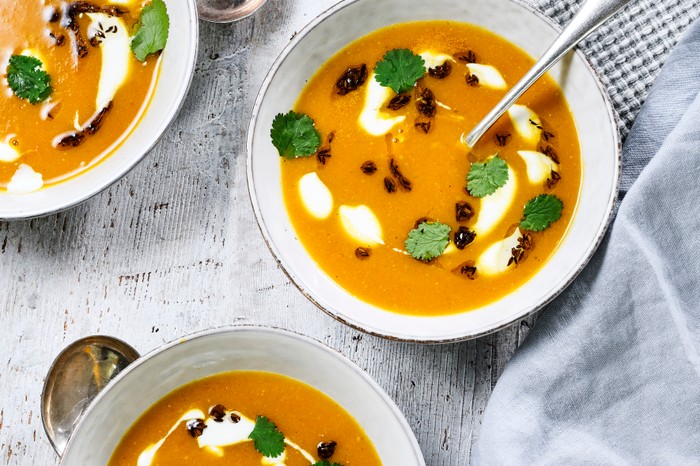 Three bowls of carrot and lentil soup