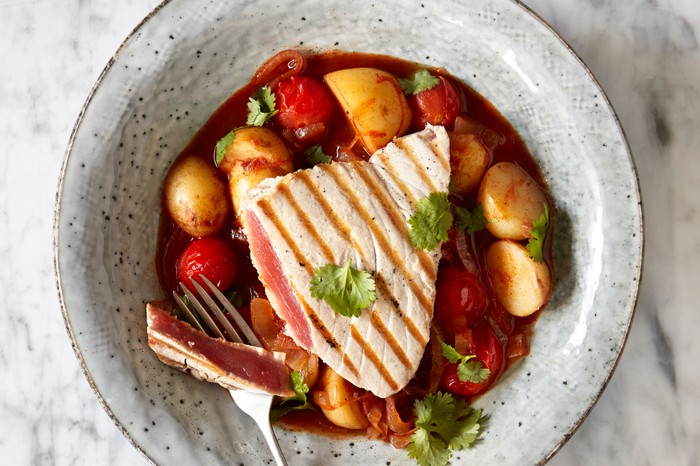 Chargrilled Tuna and Potato Stew with Harissa served in a grey bowl on a white marble surface